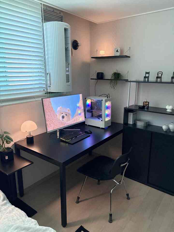 モノトーン調のワンルームホームオフィス、ブラックのデスクとRGB LEDコンピュータケースが配置された印象的な作業空間