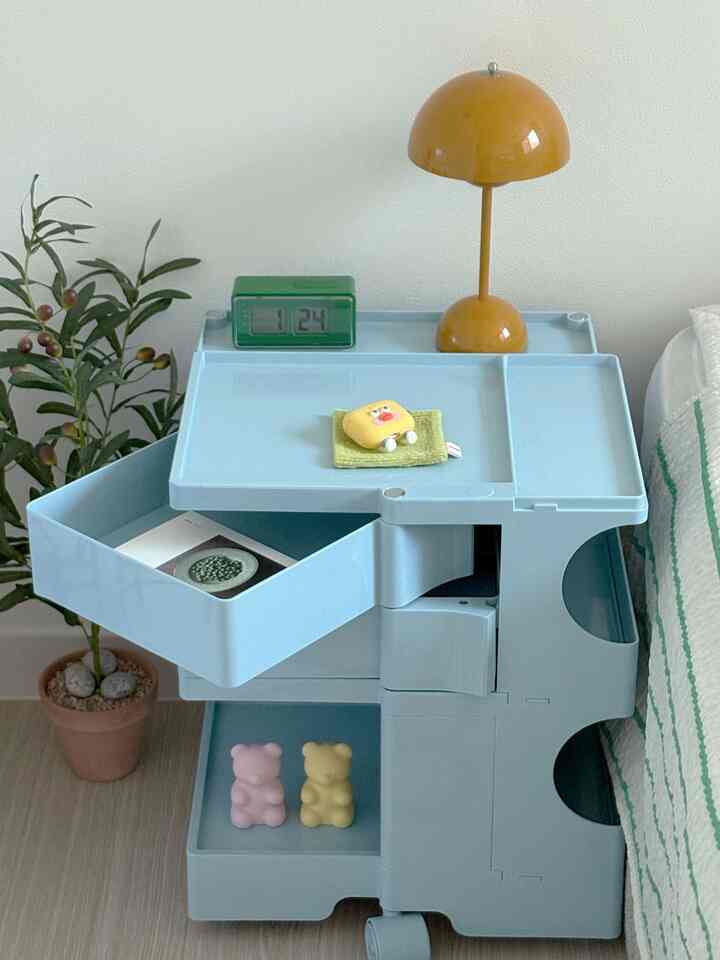 This is a review based on my own experience using and styling the product provided through the #오감리뷰 program.

While debating which side table to place next to my bed,
I decided to look for something a little more flexible this time.
I didn't initially buy the Moby Mobile Trolley to use as a side table,
but when I put it next to my bed, it felt more like a side table than a bedside table.

First of all, the design is incredible. The slightly curved silhouette and the beautiful colors
simply put it next to me completely transform the mood. Thanks to this, I feel better every morning as soon as I open my eyes.

And it's more practical than I expected. The drawers are deep and spacious, perfect for throwing in frequently used items like books, remote controls, and sleep masks.
The open storage underneath is perfect for casually storing scented candles, mood lights, and even stuffed animals.

It has wheels, so even if I rearrange my room,
I can just push it away. It's much lighter and more stable than I expected. The ABS material is smooth and sturdy, making it easy to dust and scratch easily.

I don't like trolleys that are just pretty; I prefer ones that are functional. If you're missing a storage unit, this product strikes a perfect balance between design and practicality! It enhances the ambiance of the space while also seamlessly blending into your daily routine. I'm very satisfied with it.