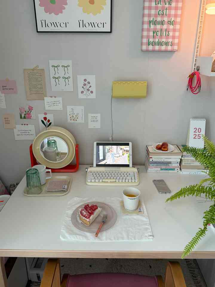 白とベージュのトーンのデスクインテリア、レトロキーボード、デザートプレートと壁デコが配置された雰囲気のあるおうちカフェ空間