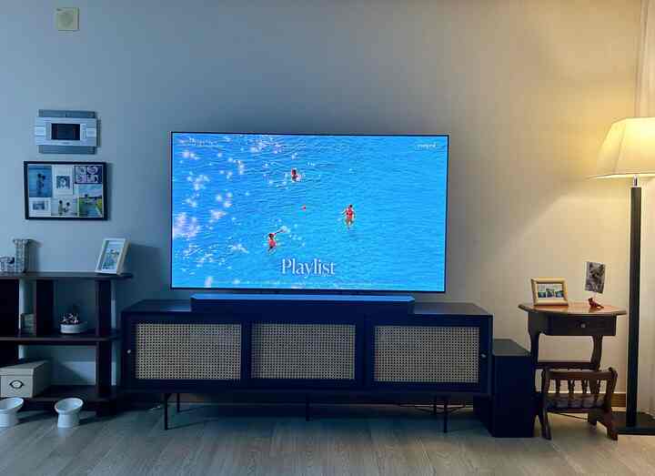 ベージュの壁とブラウンの木製家具、テレビ台とフロアランプが配置された猫と暮らすリビングの雰囲気あるインテリア