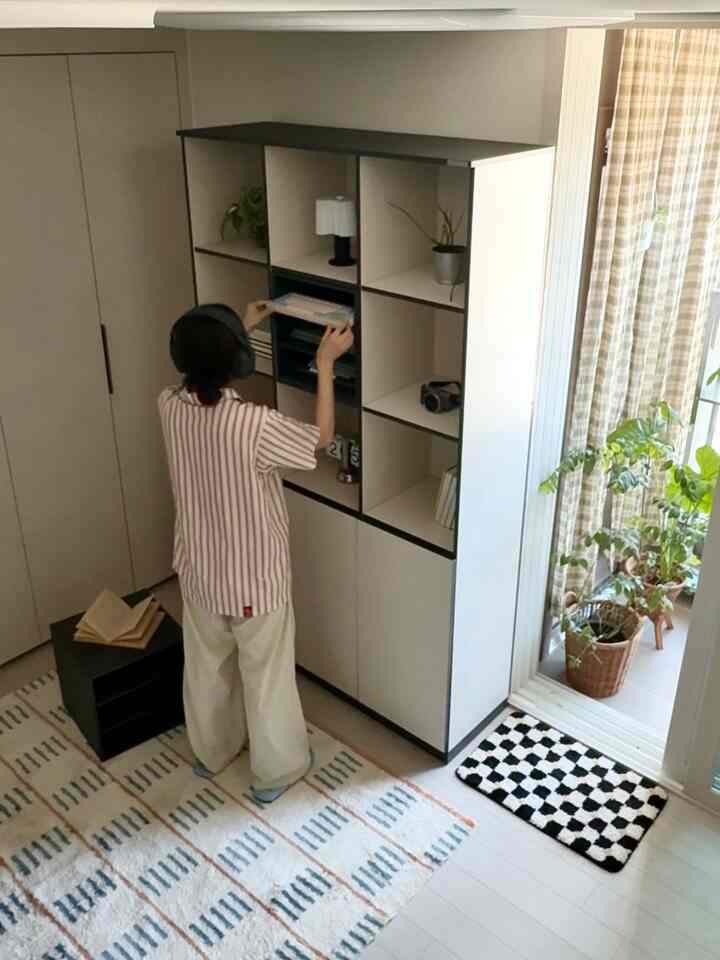 白と黒のトーンの北欧スタイルのリビング、広い収納がバルコニーの隣に配置された清潔感のある空間