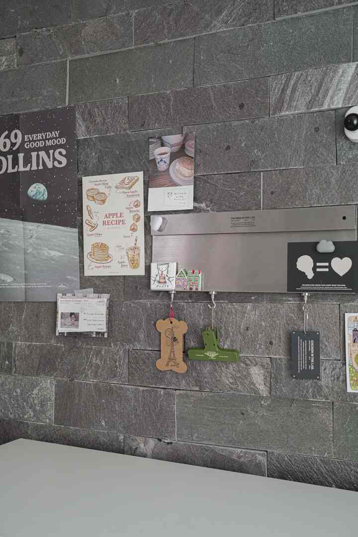 グレー調の壁にスチールボードとさまざまなポスターが配されたシンプルなインテリア