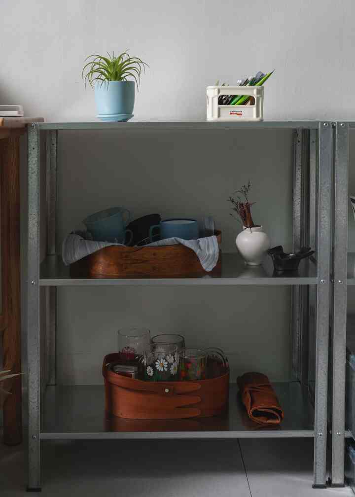 ナチュラルカラーのキッチンスペース、イケアの亜鉛メッキ金属棚にカップとオブジェが整然と配置されたシンプルなインテリア