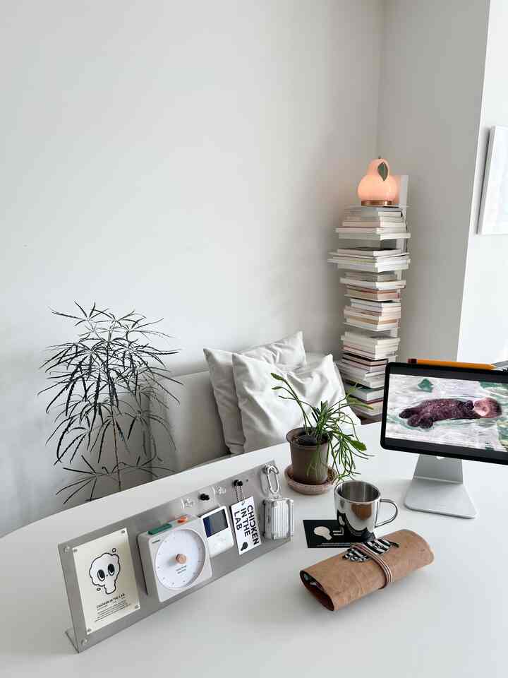 白を基調としたホームオフィス、清潔感のあるデスクと植物が配置されたモダンなインテリア