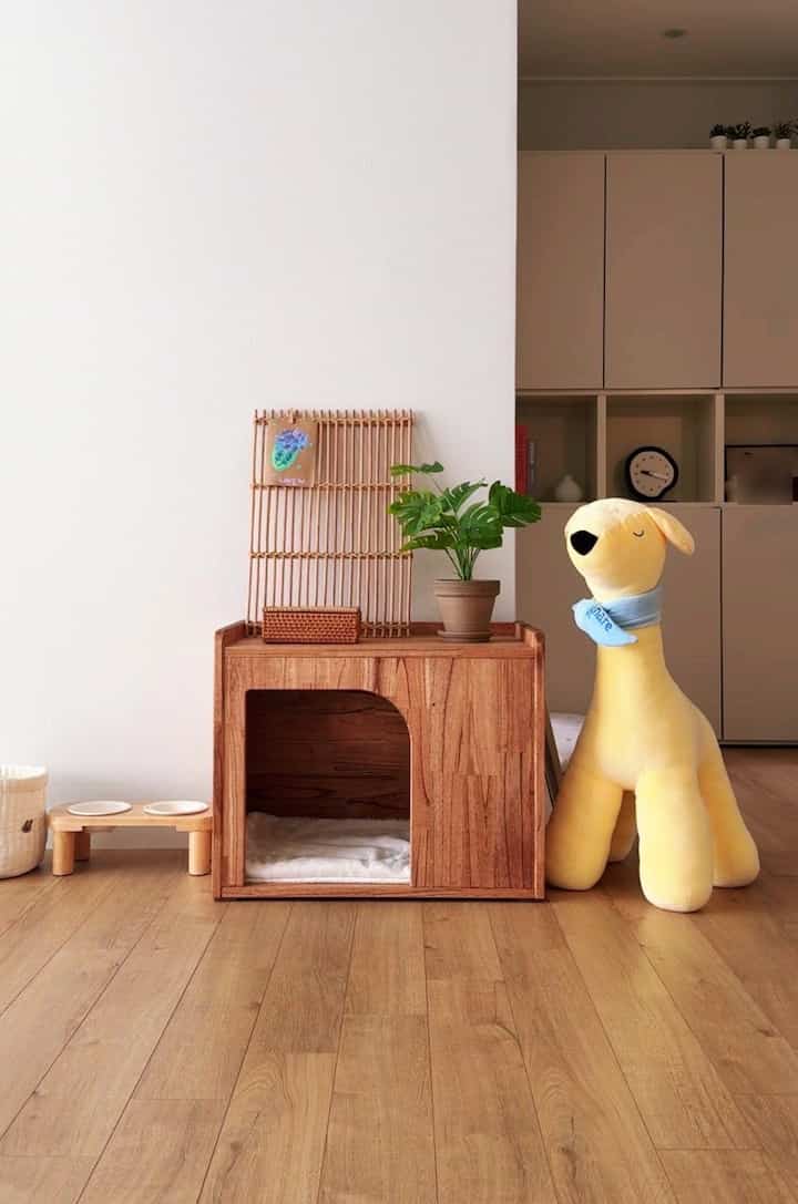 Warm wood-toned living area featuring a pet house and a plush dog toy with cozy, natural atmosphere