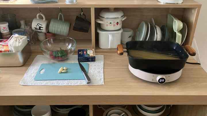 温かみのある木目調のキッチンアイランドにカップや食器が整頓された清潔感のあるキッチン