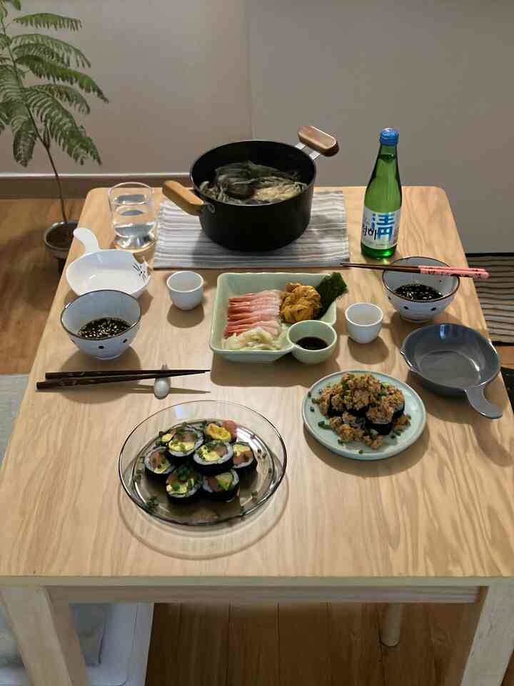 自然な木目調のキッチン空間、食卓の上に様々な料理や調理用鍋が配置された温かみのある食事の雰囲気