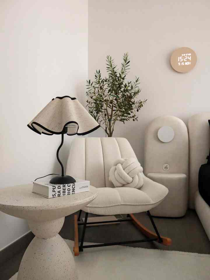 Creamy ivory tone bedroom featuring boucle chair, black accent bedding, and artificial olive tree for cozy ambiance