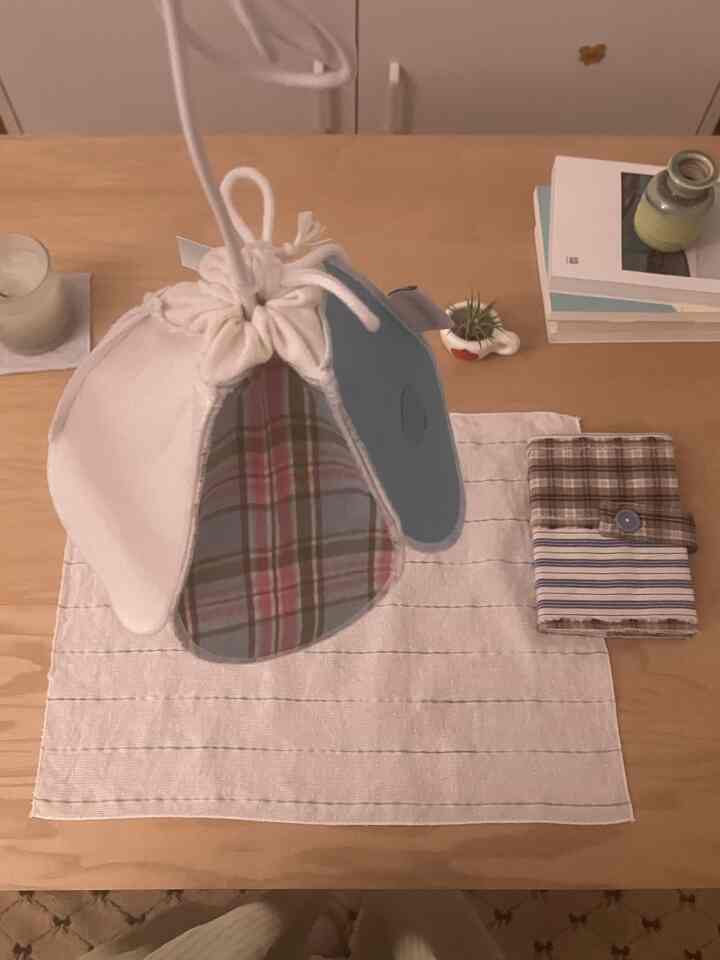 ナチュラルなベージュ色調の寝室のテーブル上に、ファブリックのパッチワーク照明が中央に吊るされた雰囲気のあるインテリア