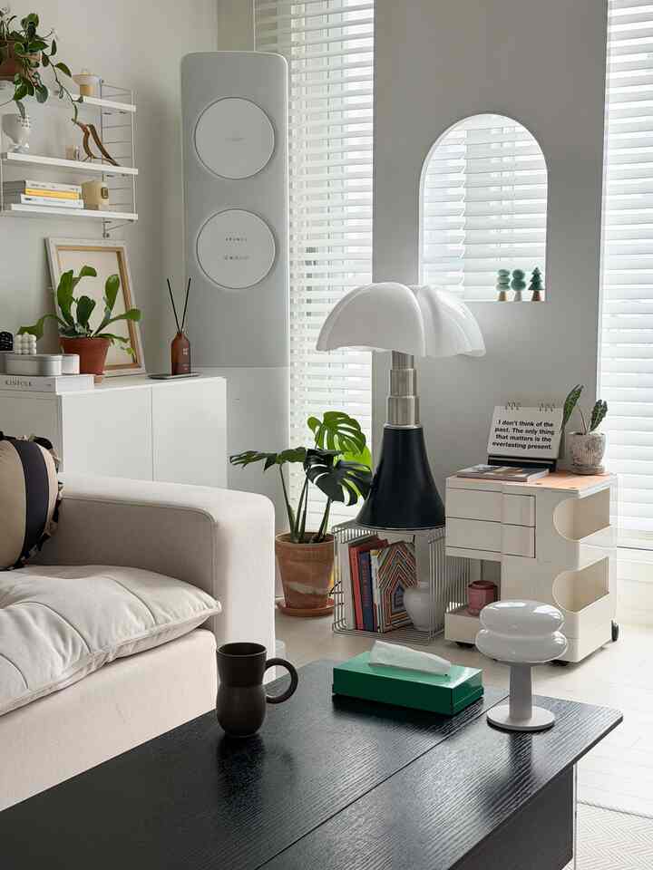 ホワイトとブラックの色調のリビング、シンプルでナチュラルなソファとテーブル、オブジェが配置された明るくモダンな空間