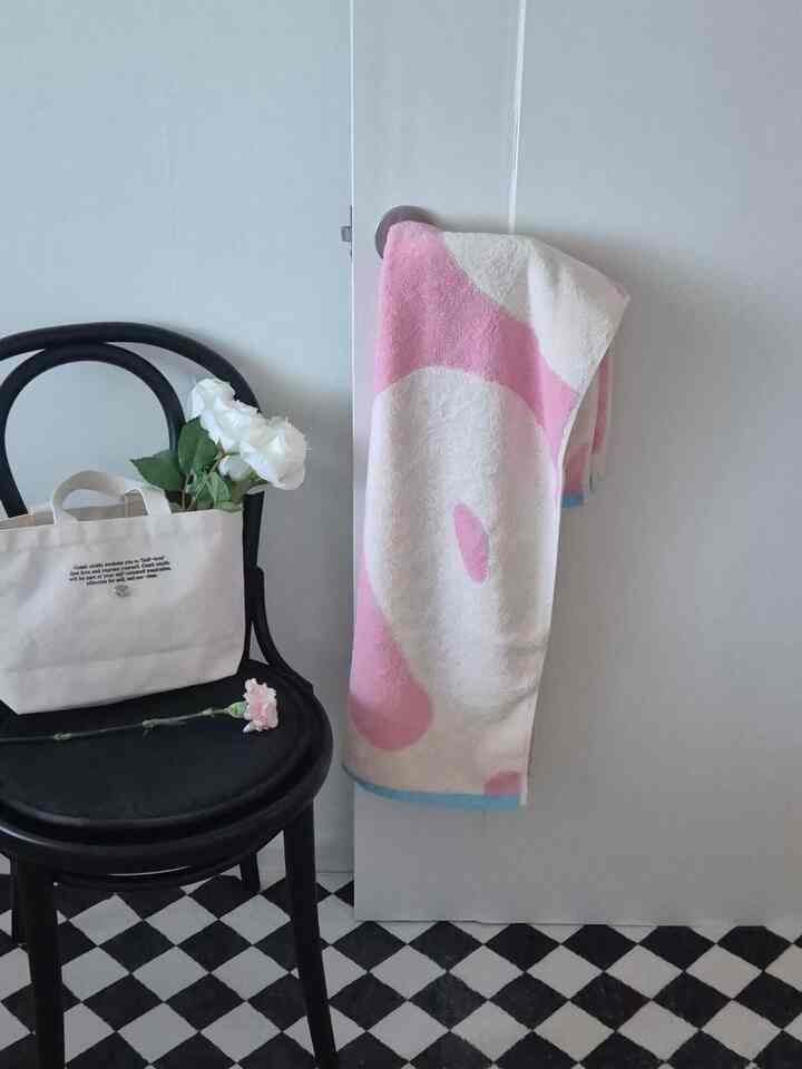 白と黒の調和が取れた空間、黒い椅子とピンクのタオル、白いバラが置かれた雰囲気のあるコーナー