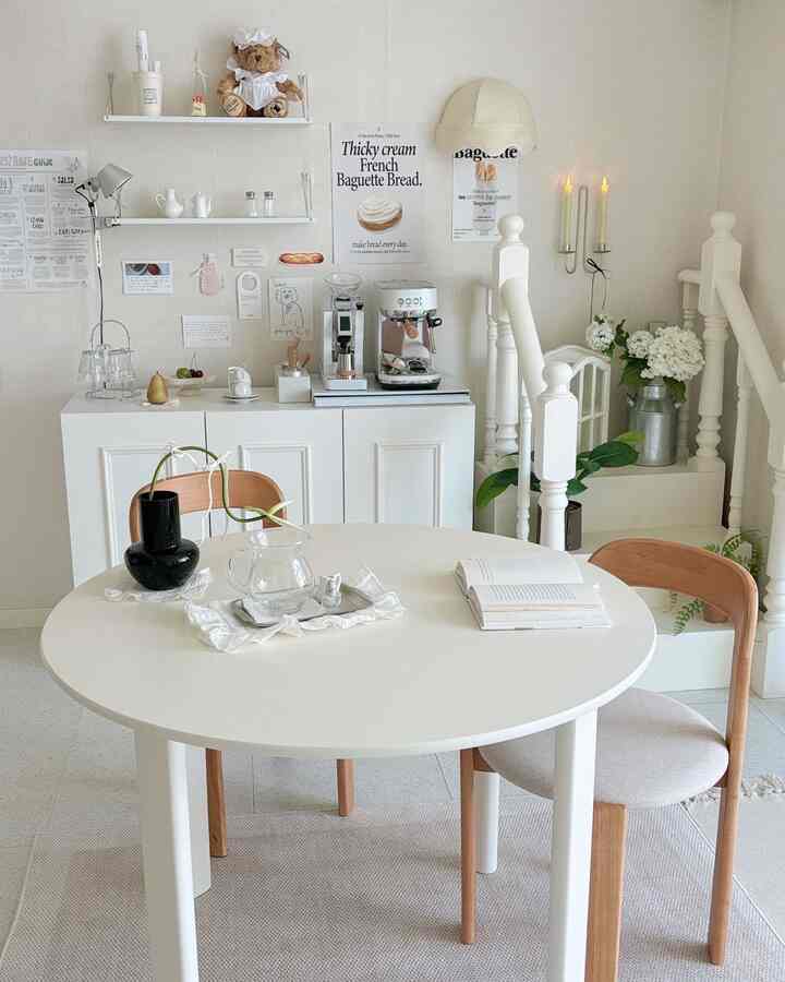 白と木目調が調和した温かみのあるダイニング、コーヒーマシンとポスターが配置された雰囲気のあるおうちカフェ空間