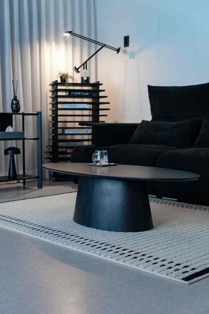 黒と白の落ち着いたリビング、中央に黒いコーヒーテーブルとソファが配置されたミニマルでモダンなインテリア