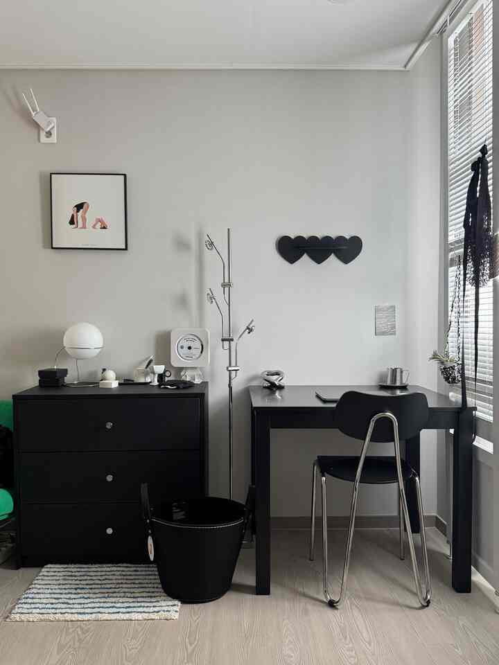 黒とグレーのトーンのホームオフィス、デスクとチェスト、オフィスチェアが配置されたシンプルで整ったインテリア