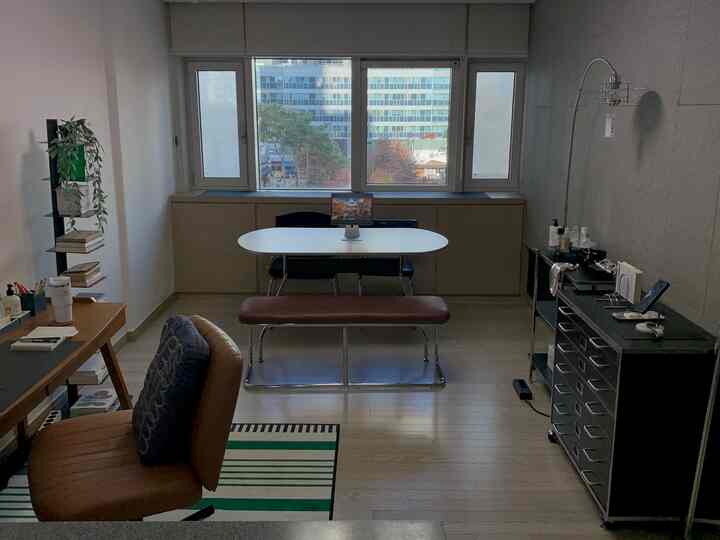 木目調の床と黒い家具が調和するモダンなホームオフィス空間、広い窓から自然光が差し込む