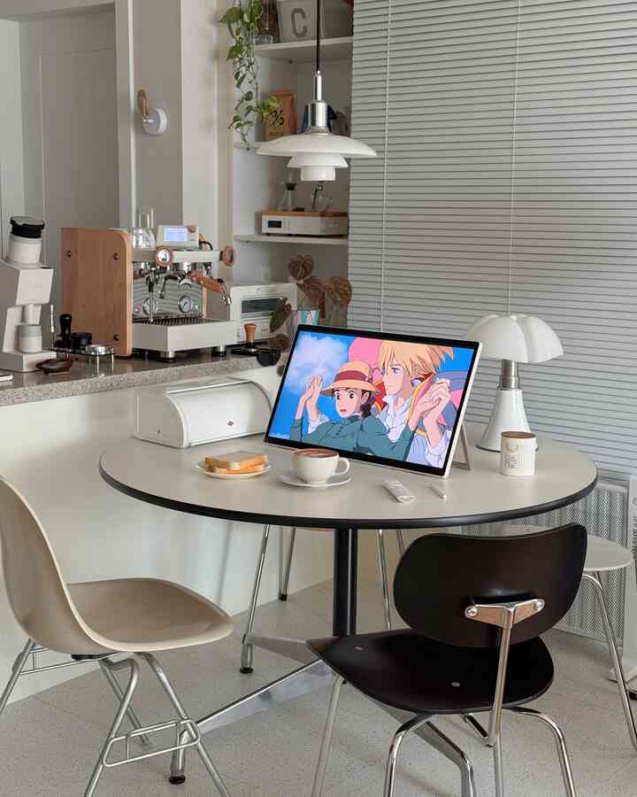 白とベージュの色調のダイニングルーム、丸テーブルと椅子、ホームカフェ設備が配置された清潔で自然な雰囲気のインテリア