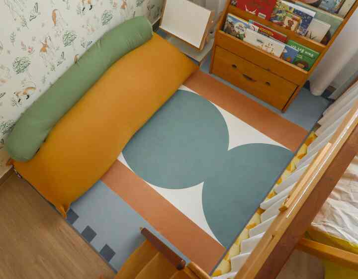 ヴィンテージ風の子供部屋、ベージュとグリーンのラグとクッションが配置された雰囲気のある空間