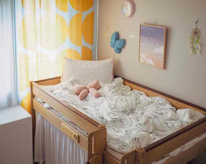 黄色のカーテンと木目調のベッドが配置された子供部屋、温かみのある雰囲気のあるインテリア