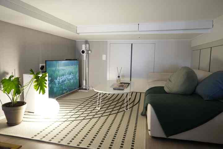 白と緑のトーンのロフトメディアルーム、ソファとコーヒーテーブル、大きなラグが配置された雰囲気のあるインテリア