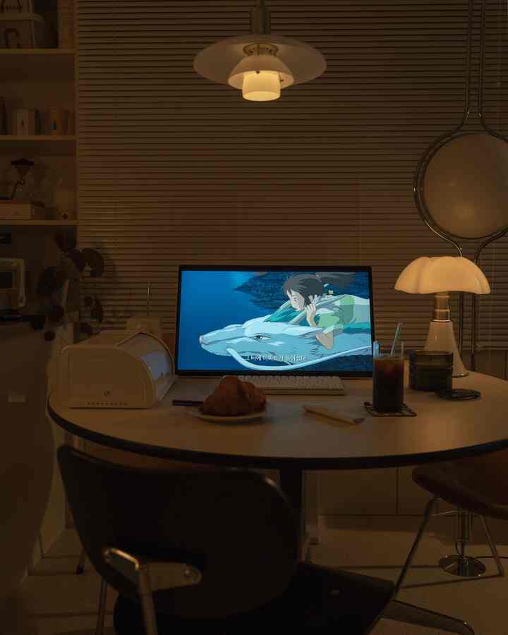 暖かい照明とベージュのブラインドがあるモダンなダイニングルーム、円形のダイニングテーブルとコーヒー、テーブルランプが落ち着いた雰囲気を作り出すインテリア