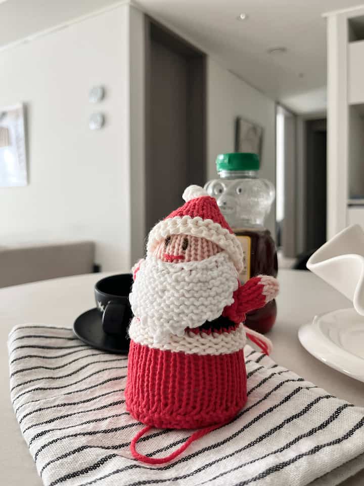 白と黒のトーンのダイニングルーム、テーブルの上にクリスマスのサンタ飾りとコーヒーカップが配置された雰囲気のあるインテリア