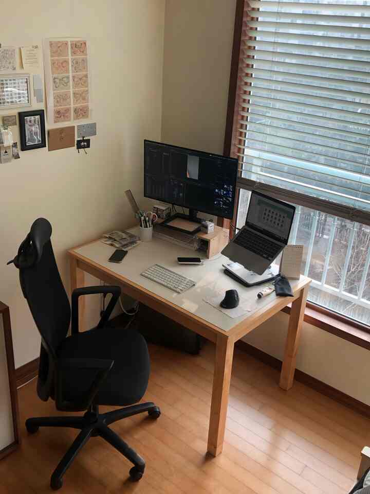 ナチュラルな木目調とブラックが調和する静かなホームオフィス空間、コンピューターデスクとオフィスチェアが配された整然とした作業環境