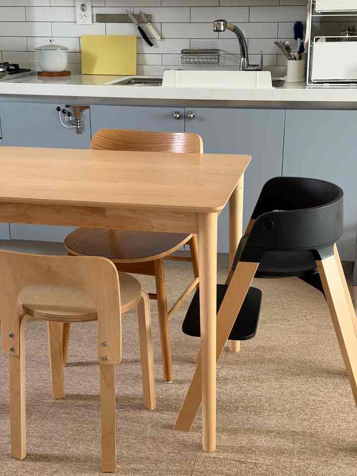 明るいナチュラルウッド調のダイニングテーブルと椅子が配置されたブルー調のキッチンダイニングルーム空間