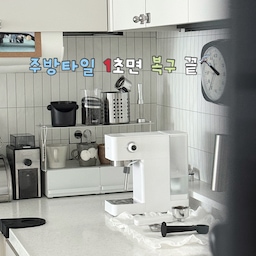 #복구가능인테리어 #주방타일 #주방타일시트지 #주방시트지 #타일시트지 #셀프시트지 #셀프시트지시공 #화이트주방 #주방인테리어 #주방인테리어소품 #주방정리 #주방선반 #홈카페 #홈카페인테리어 #홈카페소품 #홈카페꾸미기 #키친타올걸이 #원두보관 #원두그라인더 #아이가있는집 #선반손잡이 #쇠테리어
저희집 주방 타일은 아주 진한 차콜색이었어요.
그래서 고민 하다가 시트지 작업을 하였어요. 
이전 집에서 시트지를 떼어냈더니 끈끈이가 가득 남았던 기억이 있어
이번에는 꼼수를 조금 부려 보았습니다.
바로바로
우드락이 시트지를 발라서 끼워 넣기!
일단 우드락을 먼저 벽면에 맞게 재단을 한 후에 
그 위에 시트지를 바르고 
그대로 주방 타일에 끼워 넣었어요. 
모서리 끝에만 실리콘 테이프로 붙여 고정하였더이 감쪽 같이 쏙! 들어가더라고요♥
물론 단점도 있어요. 시간이 지나니 조금씩 기포가 올라오기도 하는데요
멀리서 보면 티는 잘 안 나고
언제든지 1초면 복구가 가능하고 다른 제품이나 다른 시트지 작업을 하고 싶을 때도 매우 유용하다는 점 이에요. 
이 장점이 너무 커서 저는 앞으로 주방 시트지는 늘 이렇게 작업할 것 같아요 :) 