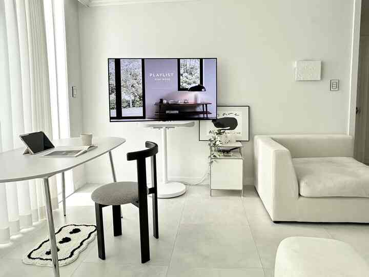 ホワイトとグレーのトーンのリビング、モダンなダイニングテーブルとソファが配置されたシンプルで印象的な空間