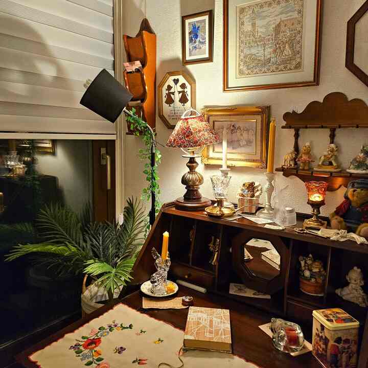 温かみのあるウッドトーンとヴィンテージの小物、照明が調和した、布地や植物が置かれた居心地の良い書斎空間