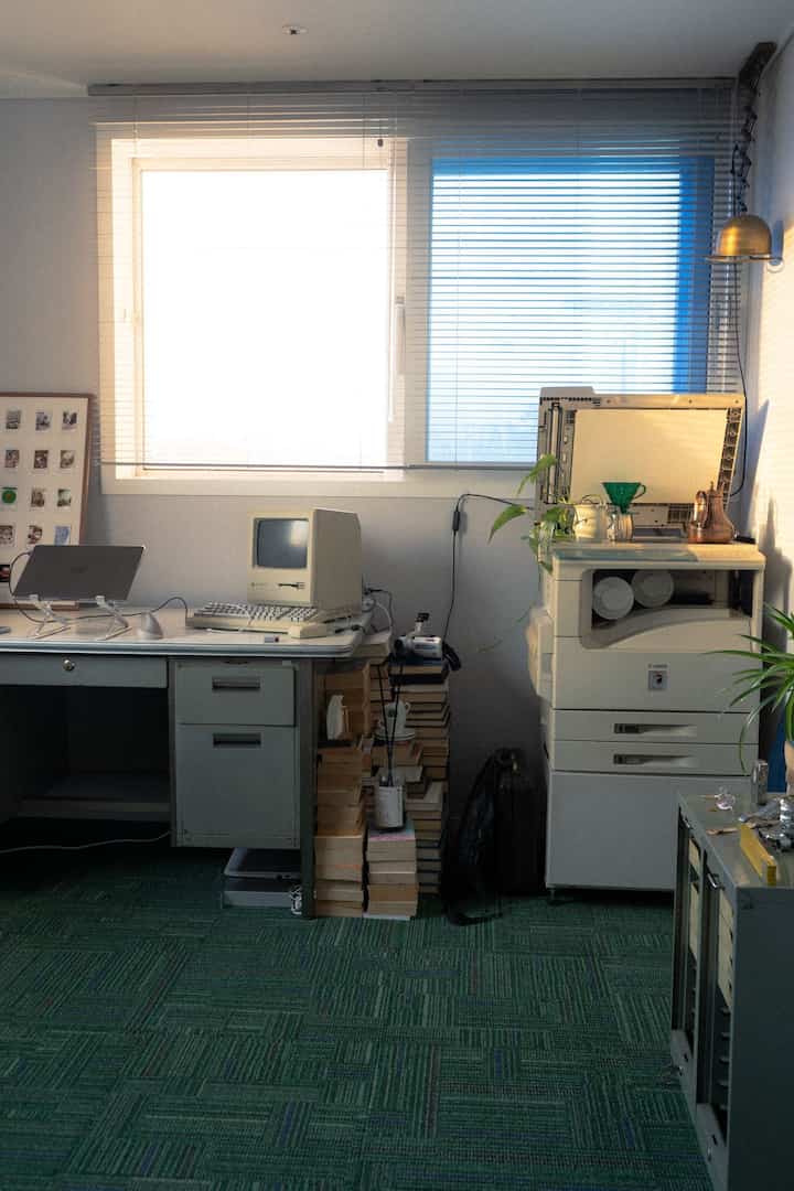 白と緑のトーンのホームオフィス、ヴィンテージコンピューターとデスク、プリンターが配置された雰囲気のあるインテリア