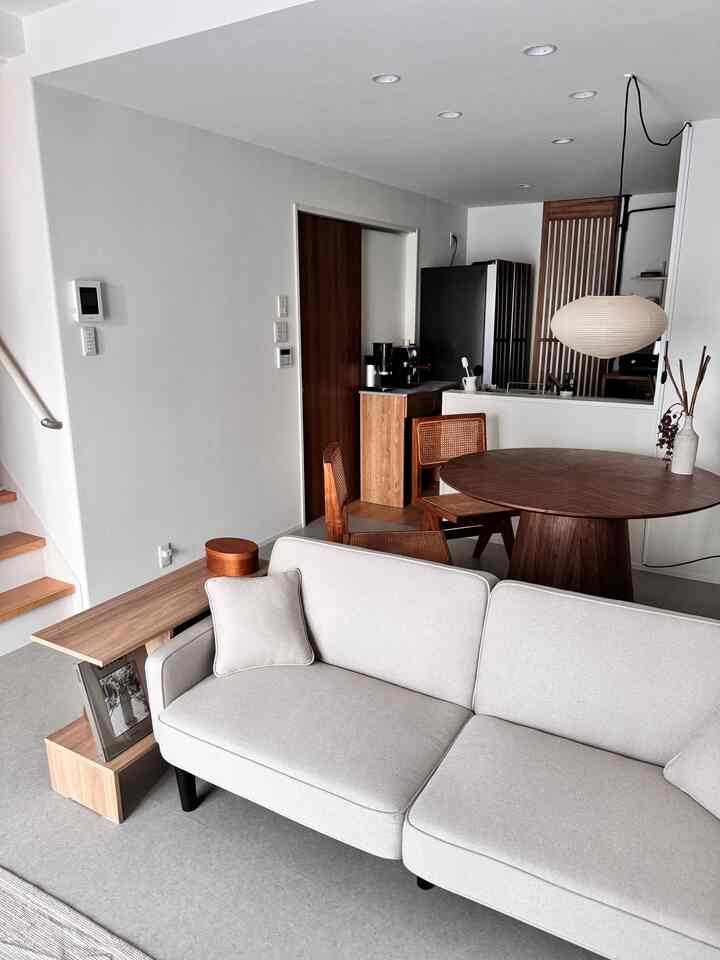 白い壁と木目調家具が配置されたシンプルな一人暮らしのリビング