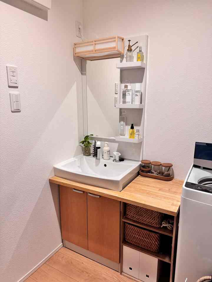 白と木目調が調和した狭いバスルーム、カスタムDIY棚と洗面台が配置された実用的な空間