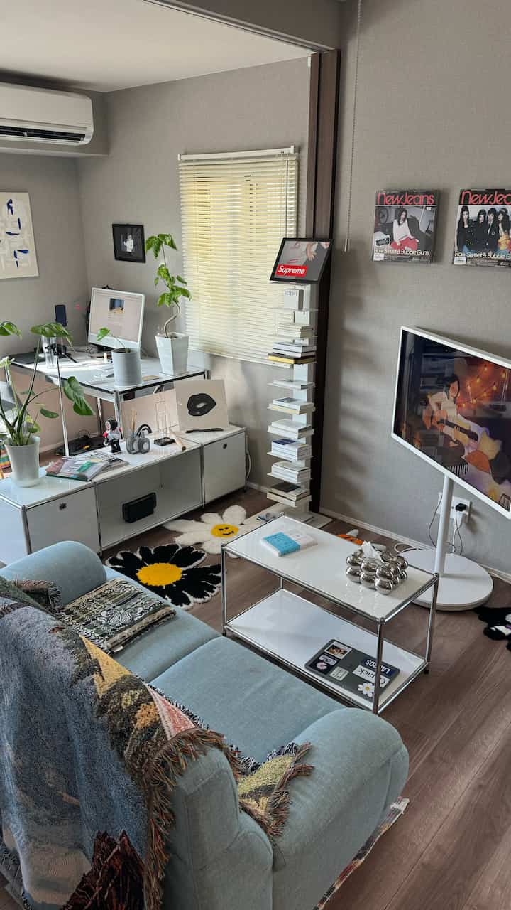 白とシルバーのトーンが特徴のリビングとワークスペース、シンプルでモダンな家具が配置された印象的な空間