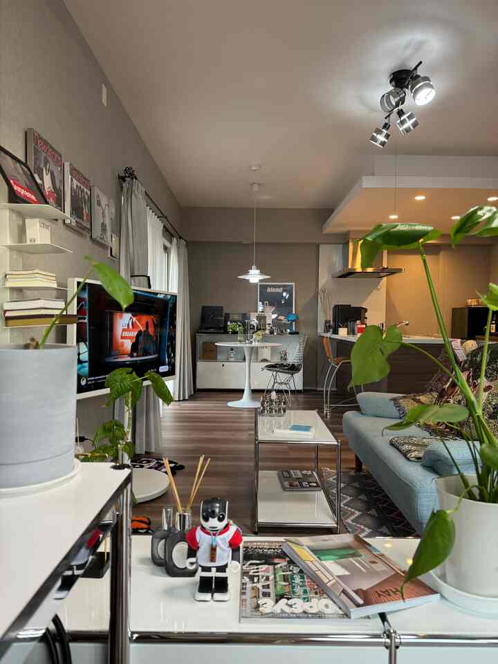 白とシルバーのトーンで統一されたモダンなリビングとダイニング、ダイニングチェアとソファが配置された落ち着いた空間