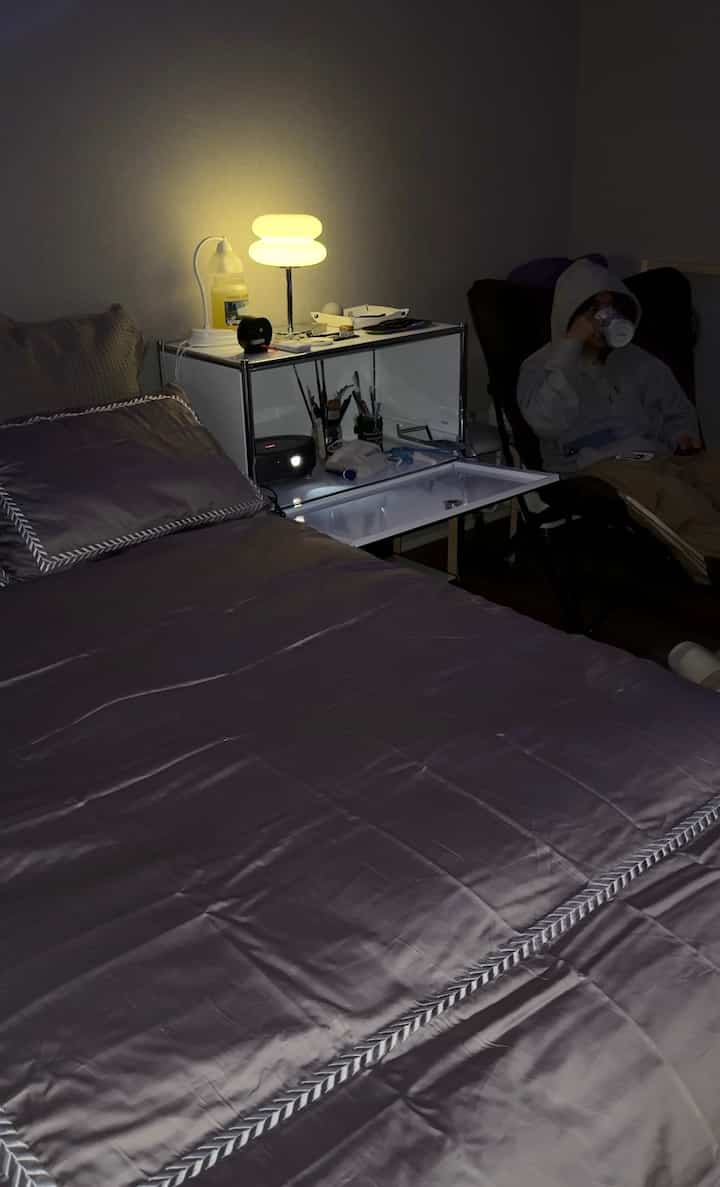 パープルグレーの寝具と照明があるシンプルでコンパクトな一人暮らし用寝室のインテリア