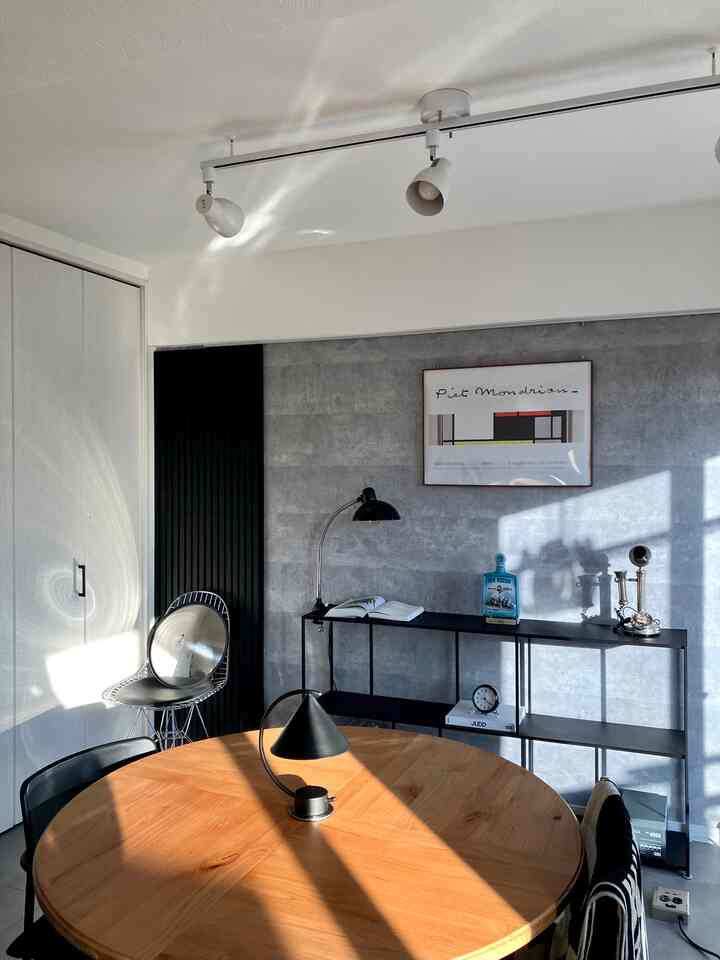 ナチュラルな木目調とブラックが調和するダイニング、ラウンドテーブルとテーブルランプが配置された落ち着いた雰囲気のインテリア