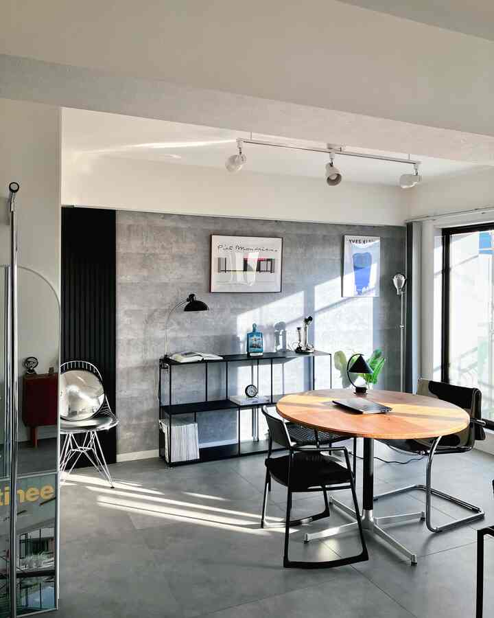 明るく自然光が入るモダンでナチュラルモダンなホームオフィス空間、丸テーブルと本棚が配置されている