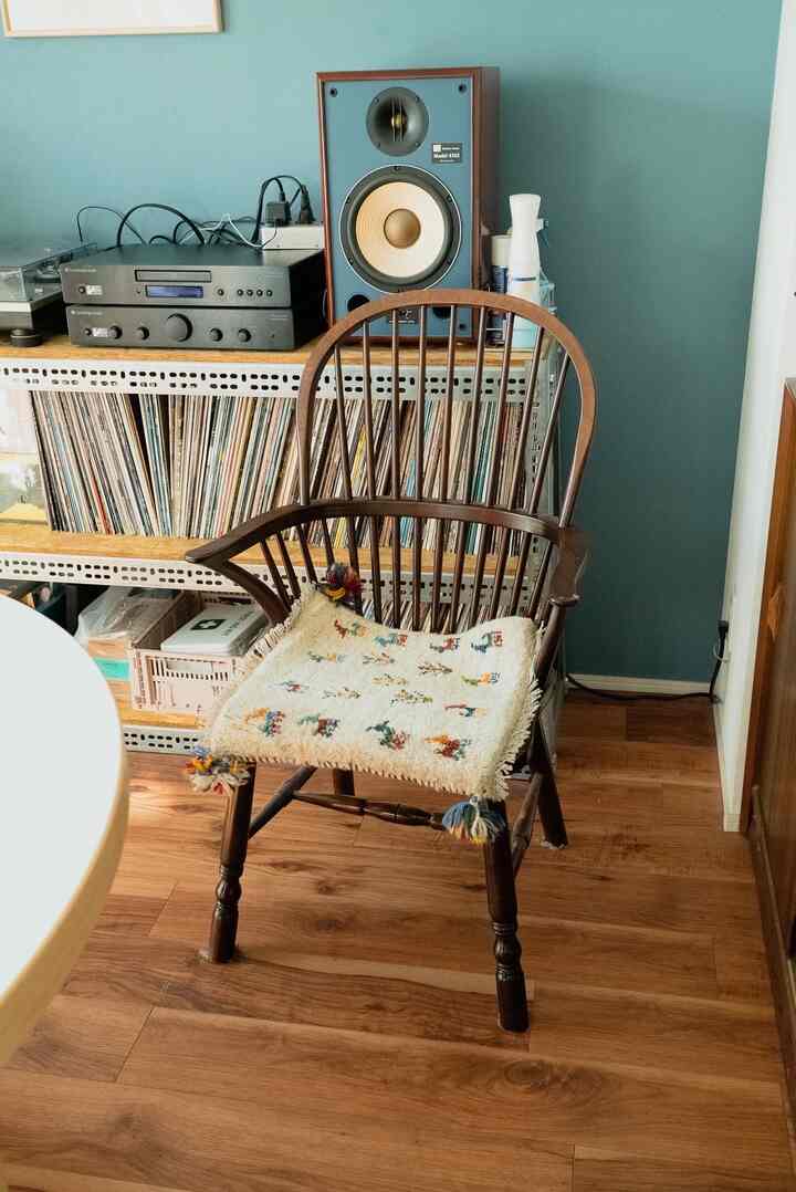 木目調と青い壁が調和するヴィンテージスタイルのリビング、509C型ウィンザーチェアとオーディオ機器が配置された落ち着いた空間