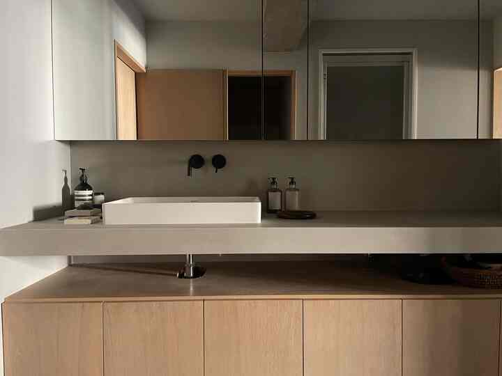 落ち着いたグレーの色調とナチュラルな木材が調和したモダンなバスルームの化粧台スペース