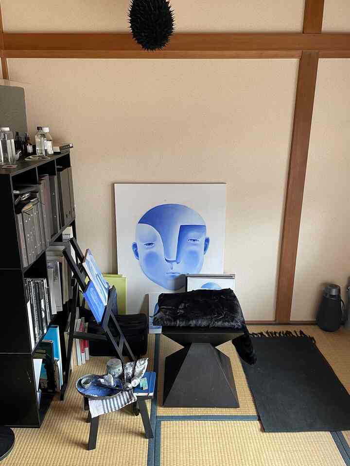 黒い家具と自然な色調の壁が調和する和室、アート作品と画材が配置された印象的なモダン空間