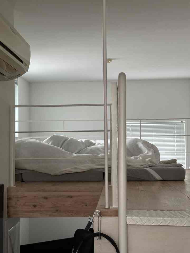 ナチュラルカラーの狭い部屋のロフト寝室、白い壁と木目調の床が調和した雰囲気のあるインテリア