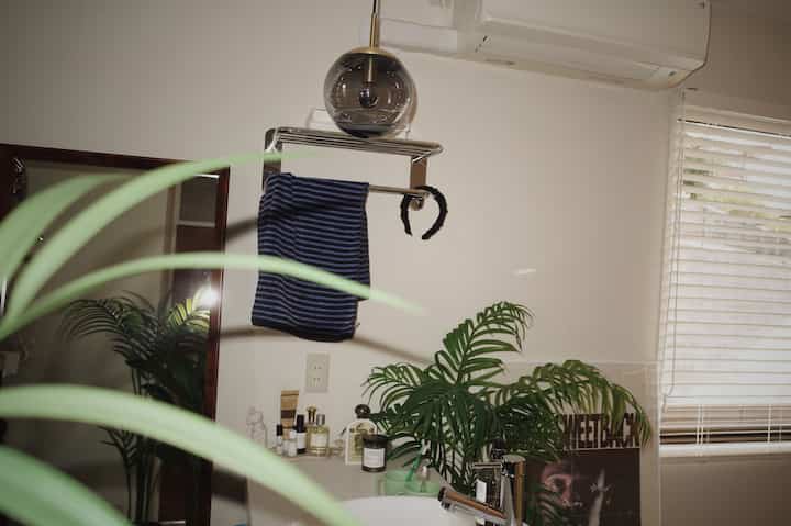 グレーの照明とグリーン植物が配置されたシンプルなバスルーム・パウダールームの雰囲気のあるインテリア