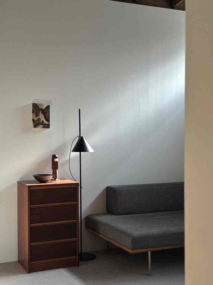 グレーのソファと茶色のチェストが配置された、ナチュラルなスカンジナビアスタイルのリビングルーム