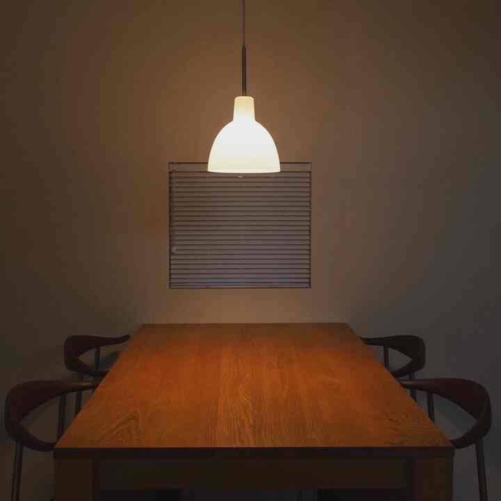 暖かい木目調のダイニングルーム、ペンダントライトが柔らかく照らす雰囲気のある空間