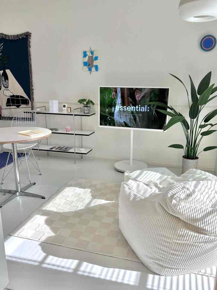 ホワイトトーンの4.5畳リビング、ビーズクッションソファとテレビが配置され自然光が差し込む印象的な空間