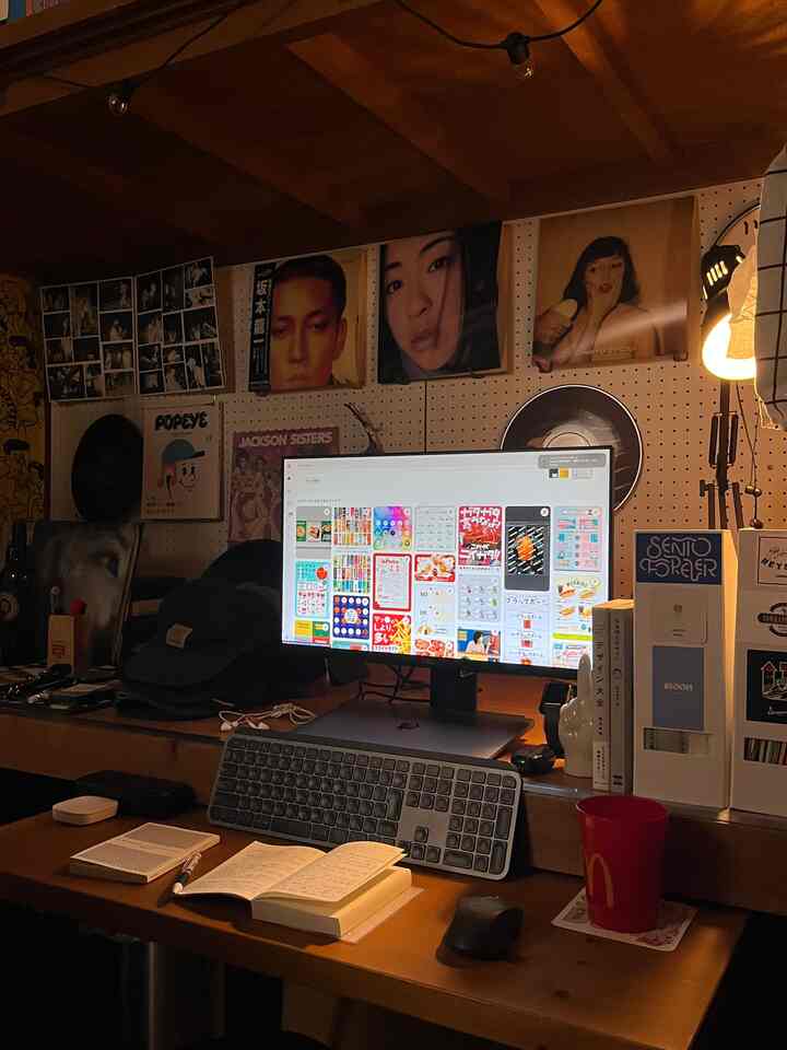 暖かみのある木目調のホームオフィス、机とモニター、雰囲気の良い照明が配置された居心地の良い作業空間