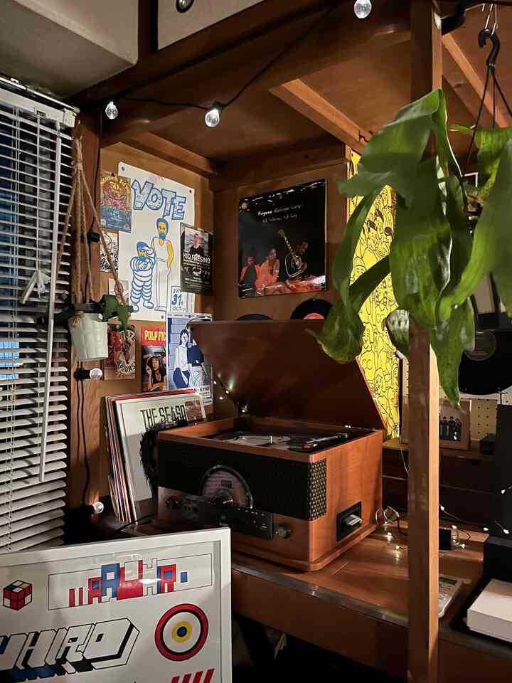 温かみのある木目調とレトロな雰囲気が漂う小さな音楽鑑賞スペース、IONのターンテーブルと植物が配置された印象的な空間