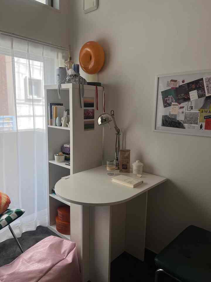 シンプルな白いテーブルと本棚が配置された、ナチュラルモダンなリビングダイニングのインテリア