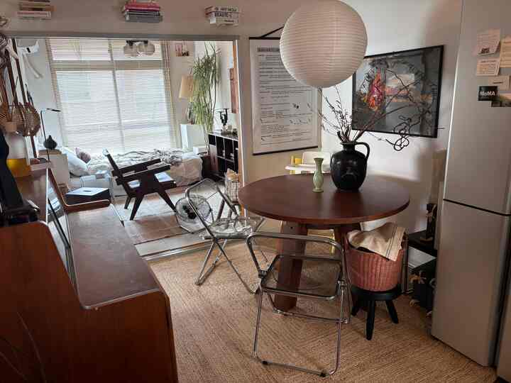 白とナチュラルな色調のモダンな二人暮らし向け寝室とダイニングテーブルが配置された雰囲気のある空間